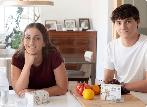 dos jovenes con el probiotico en la mesa
